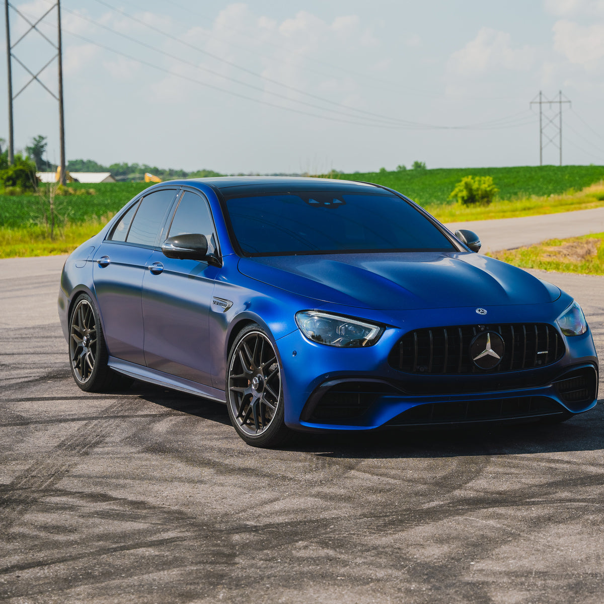 Blue Mercedes-AMG sedan photographed outdoors.